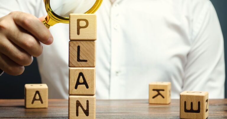 Muž řeší s lupou, jak postupovat při tvorbě, jak vytvořit publikační plán.